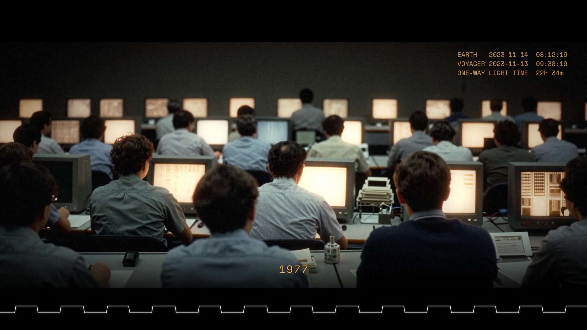 Signal Delay: a 1977 mission control room seen from behind rows of engineers at amber terminals, two clocks in the corner reading Earth and Voyager time, a square-wave readout along the bottom